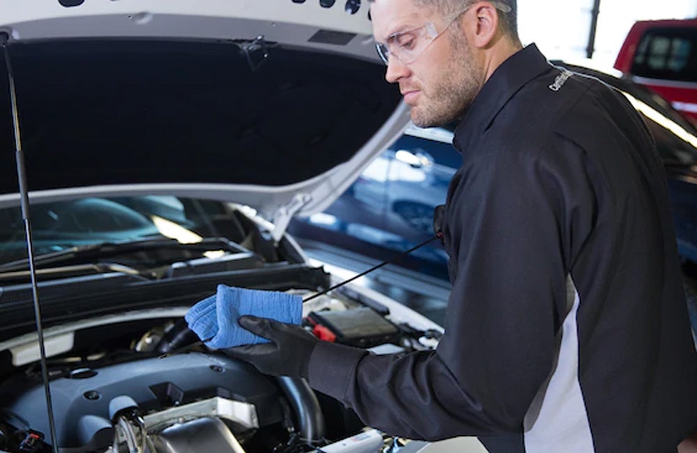 Mechanic performing oil change on vehicle